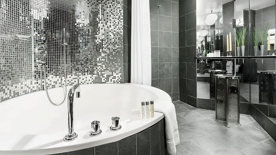Indulge in a deep soaking tub beside shimmering spa-like tile.