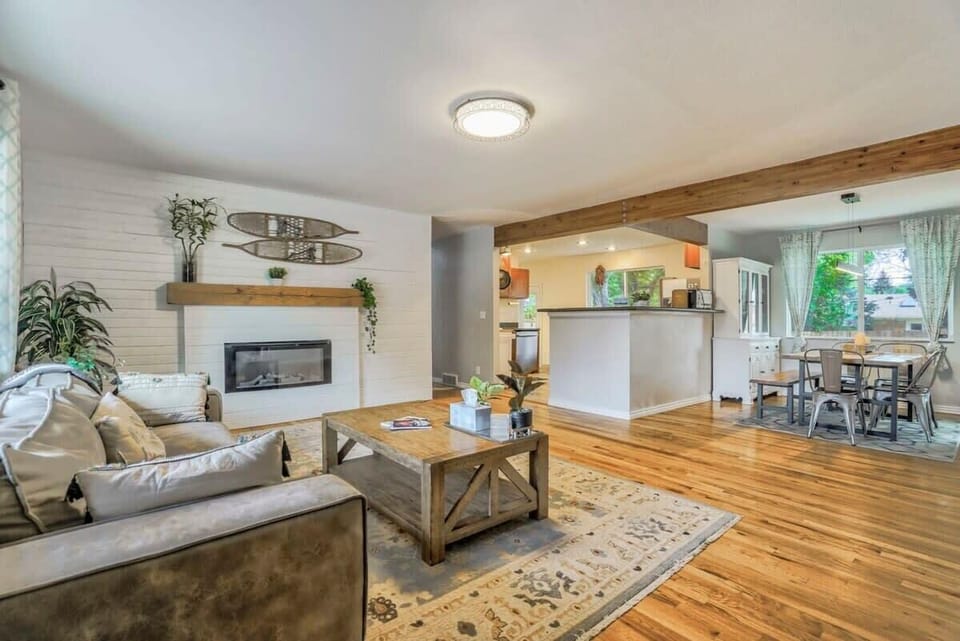 Bright, open living area with a cozy fireplace and plenty of room to lounge, flowing right into the kitchen and dining space for easy hangouts.