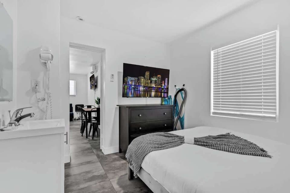 Unwind in this cozy room with patterned throws, mounted TV, and in-room vanity—ideal for solo guests or couples.