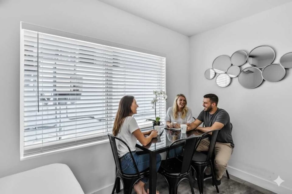 Share laughs and coffee around this stylish dining table with orchid centerpiece. A bright, welcoming space perfect for group stays, remote work, or casual meals in your vacation rental.