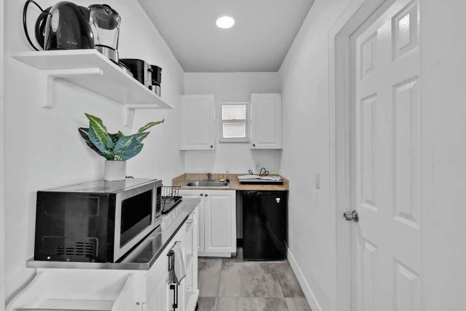 Cook, brew, and unwind in this efficient kitchenette with microwave, coffee maker, and stylish open shelving. Perfect for extended stays or weekend escapes.

