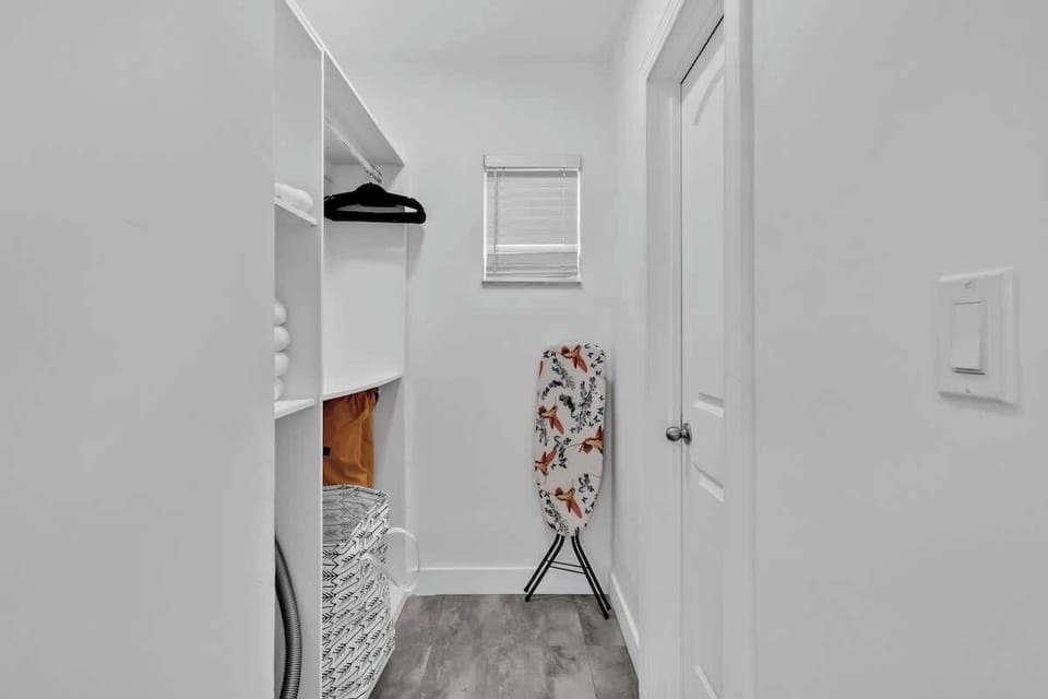 Stay fresh with this organized laundry nook featuring built-in shelves, ironing board, and natural light. Great for long-term stays and family trips.