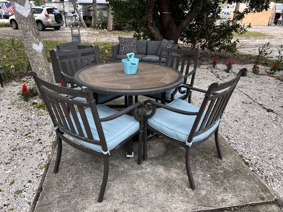 outside dining and lounge area with coffee table couch and chair