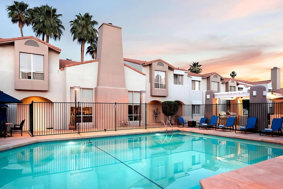 Unwind poolside at sunset with sparkling water and palms.