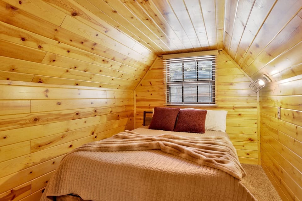 Peaceful cabin bedroom with plush bedding, and beautiful views—ideal for restful nights, cozy mornings, and a relaxing mountain escape.