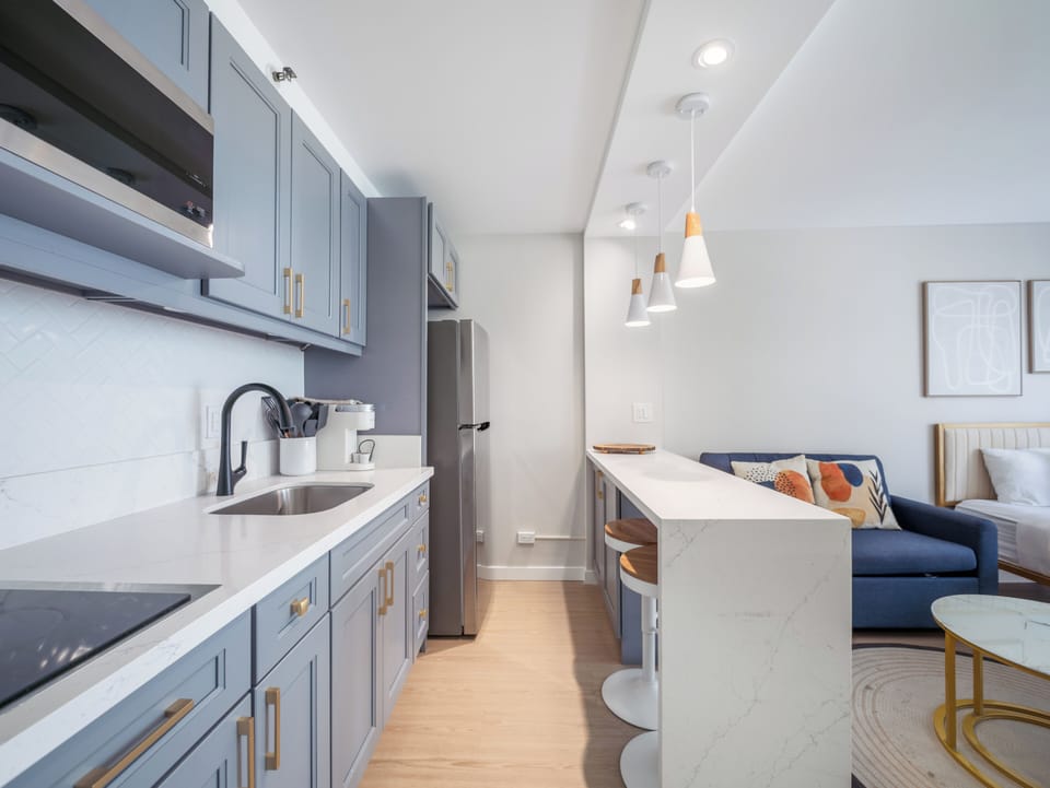 Full Kitchen with microwave, stovetop, and refrigerator - Full kitchen with dining area, refrigerator, microwave, cooktop, garbage disposal, Kureg Coffee maker, basic cookware, dishes, and utensils