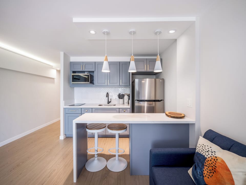 Full Kitchen with microwave, stovetop, and refrigerator - Full kitchen with dining area, refrigerator, microwave, cooktop, garbage disposal, Kureg Coffee maker, basic cookware, dishes, and utensils