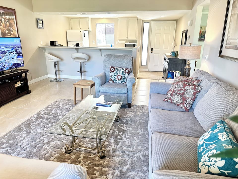 Open concept living room which has view of kitchen and view of golf course 