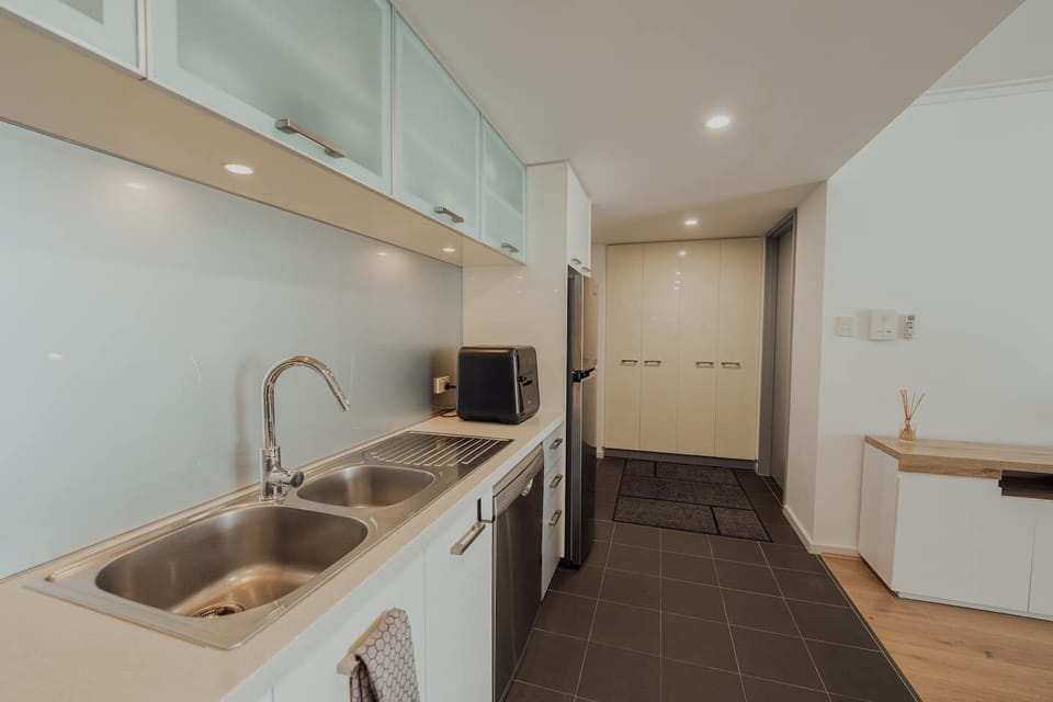 Prepare delicious meals in this kitchen, featuring sleek countertops, modern appliances, and ample workspace.