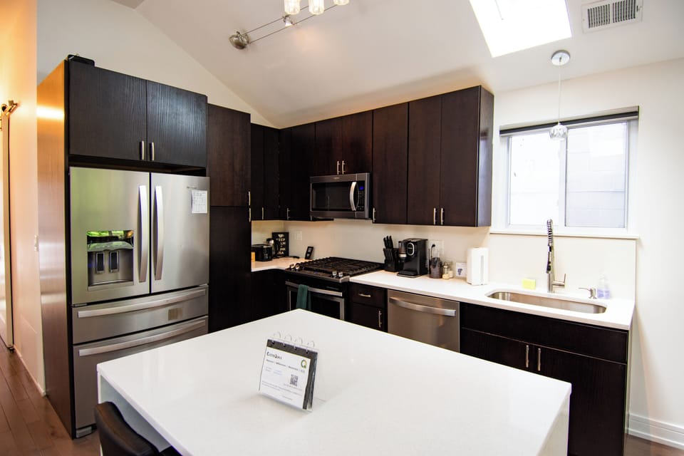 Modern chef’s kitchen with island, skylight, and stainless appliances