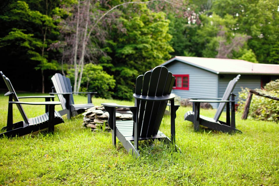 Adirondack chairs surrounding a fire pit to sit and relax in.