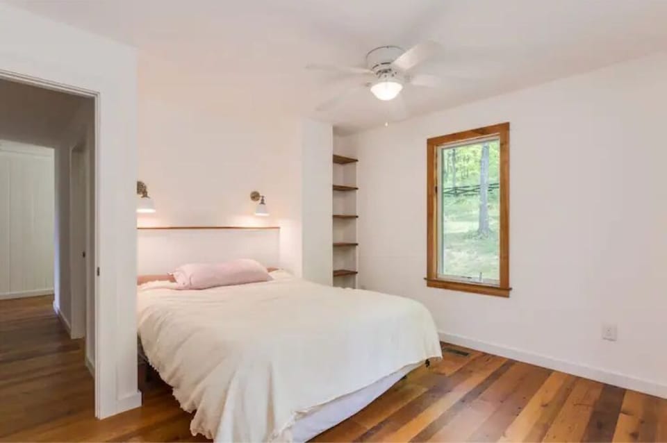 Queen bedroom #1 with woods view and built-in shelving.