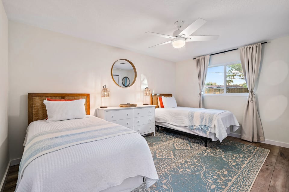 Two twin beds with blackout shades and bifold closet.