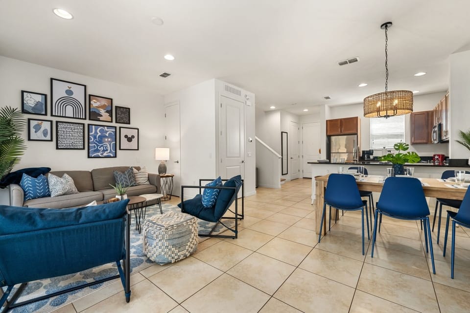 Relax in the open-concept living area with cozy seating, smart TV, and subtle Mickey-inspired touches.