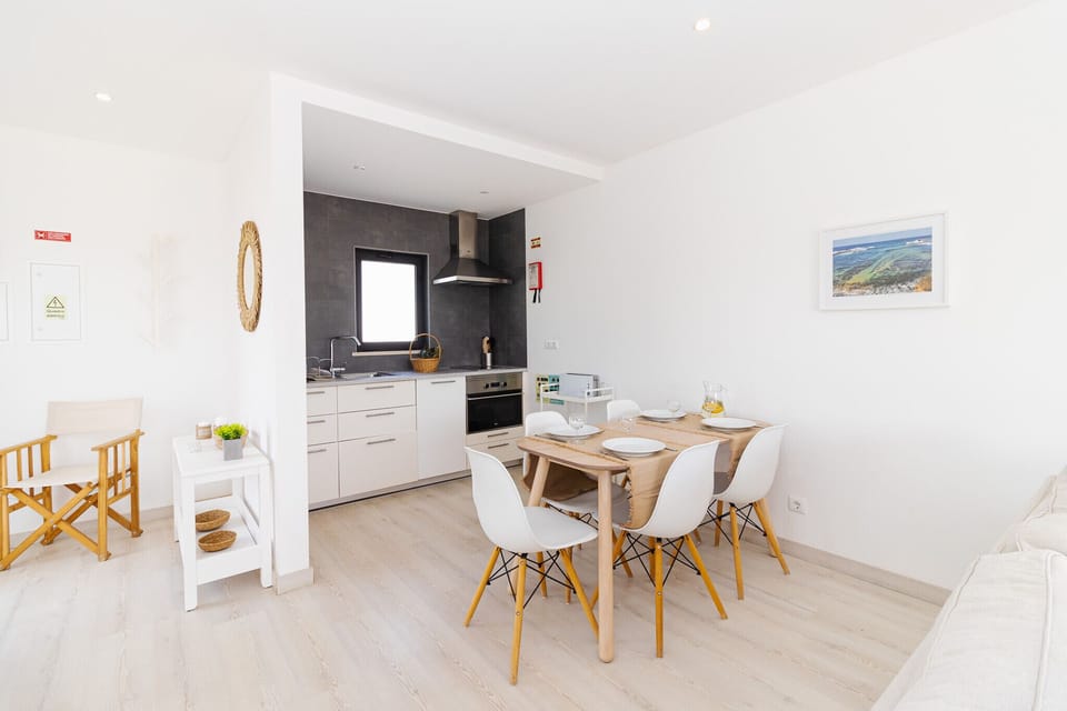 Open-plan kitchen and dining area with wooden table — Villa Alcione, luxury holiday villa in Vila do Bispo