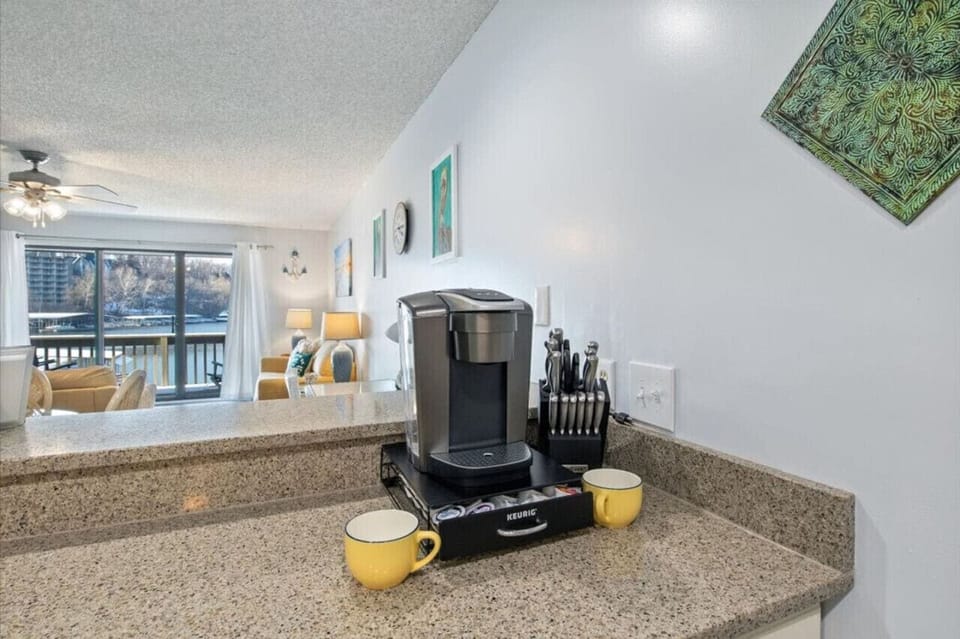 Keriug Elite coffee maker with diverse coffee cup and grounds provided. Large coffee pot and filters also provided under cabinet.