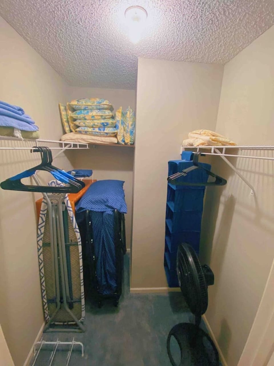 Closet located inside the master bedroom contains: hangers, extra linens, extra blankets, extra pillows, fan, iron & ironing board, and a fold up plush twin mattress.