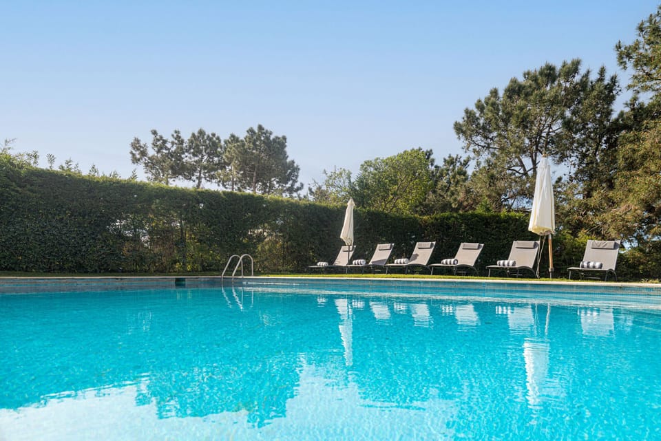 Crystal-clear swimming pool with loungers and umbrellas — Villa Yara, luxury holiday villa in Grândola