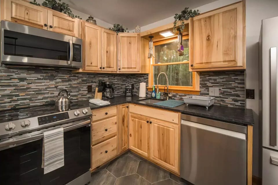 A well-equipped kitchen with a stove, oven, microwave, and essentials.