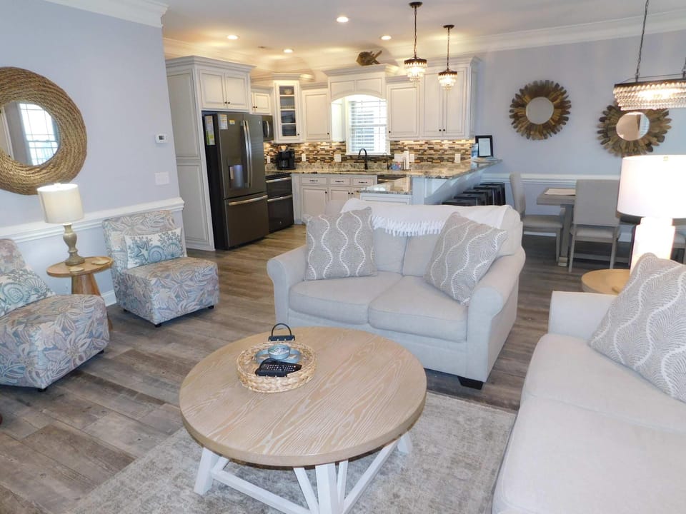 Spacious living room with cozy seating and modern kitchen view