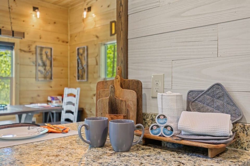 Rustic kitchen counter with coffee mugs and wooden cutting boards for a cozy start to your day.