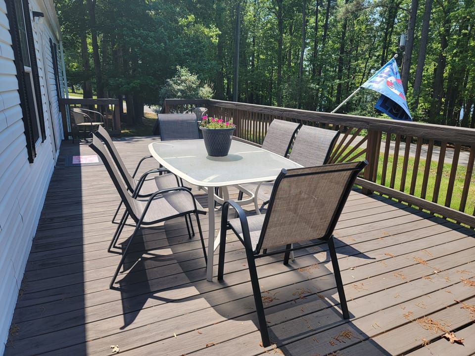 Large front porch with dining for six, reading  a book or playing cards.