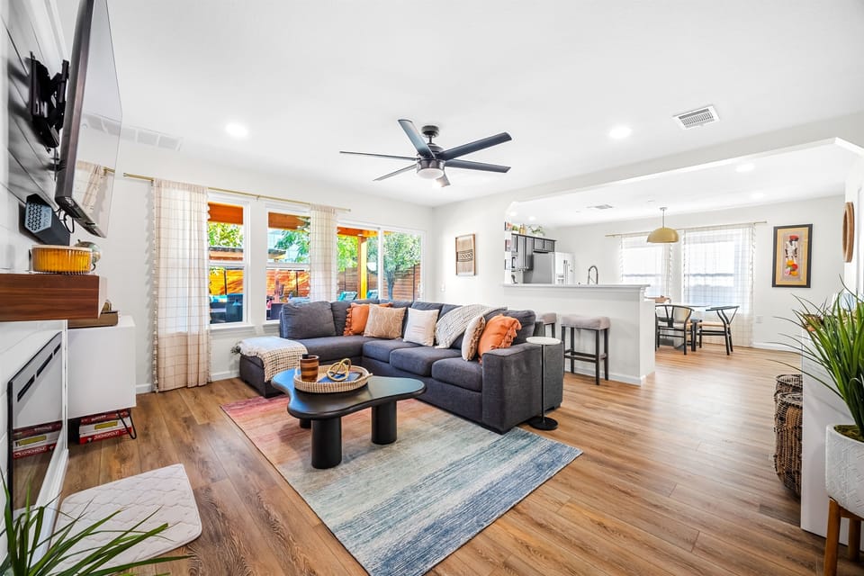 Step into this inviting haven, where natural light floods in, creating a bright and spacious living area that beckons you to gather with loved ones. With a sleek TV at the center, it's the perfect backdrop for unforgettable family moments.