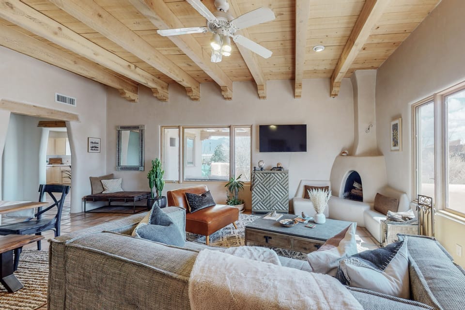 Living room with kiva fireplace and Sandia mountain views