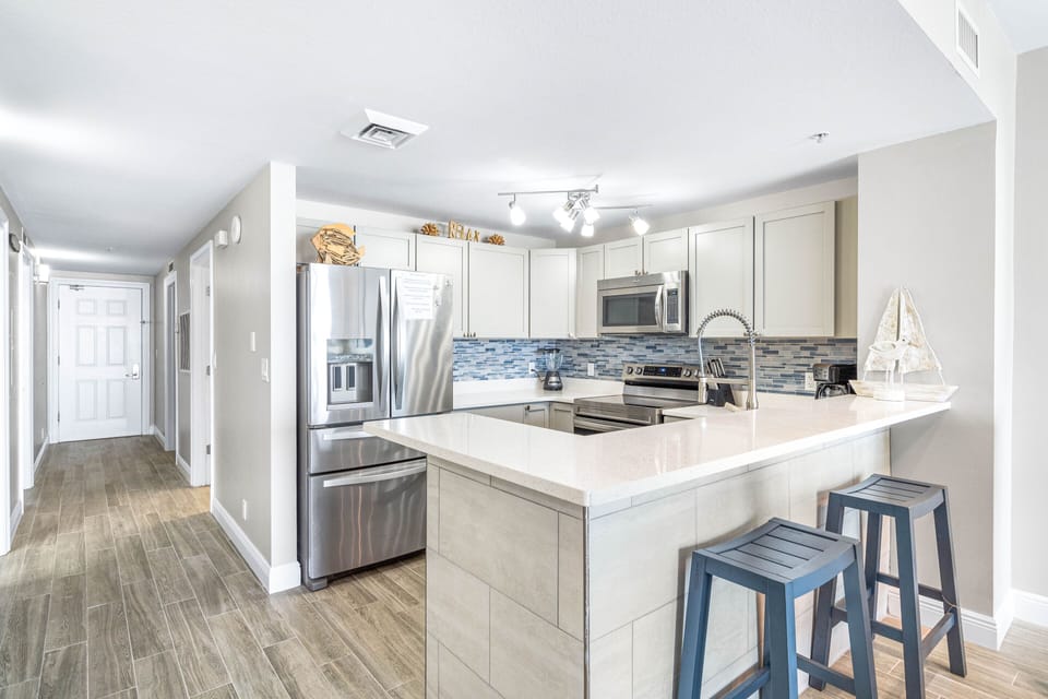Full size kitchen to cook in with bar stools for kids to have a quick snack between activities.