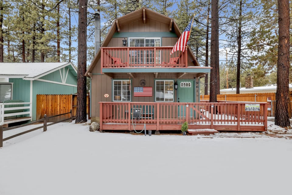 Welcoming cabin entry surrounded by towering pine trees, offering fresh mountain air and a peaceful forest setting—the perfect first impression for your Big Bear Lake getaway.