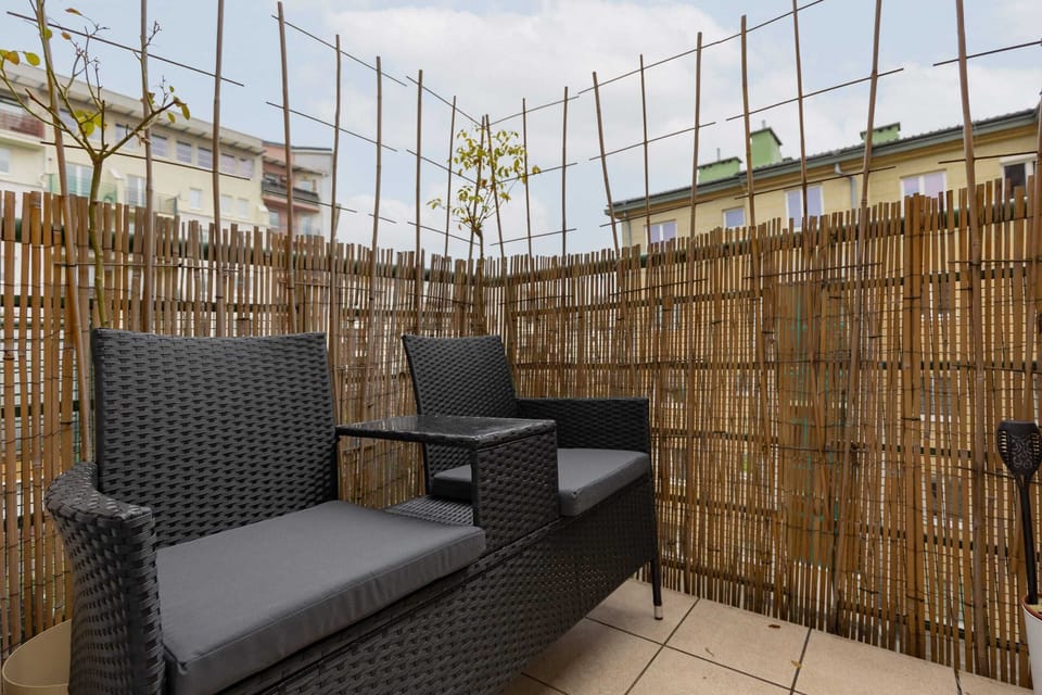 Spacious balcony with outdoor furniture. 