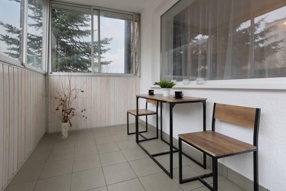 Spacious balcony with outdoor furniture. 