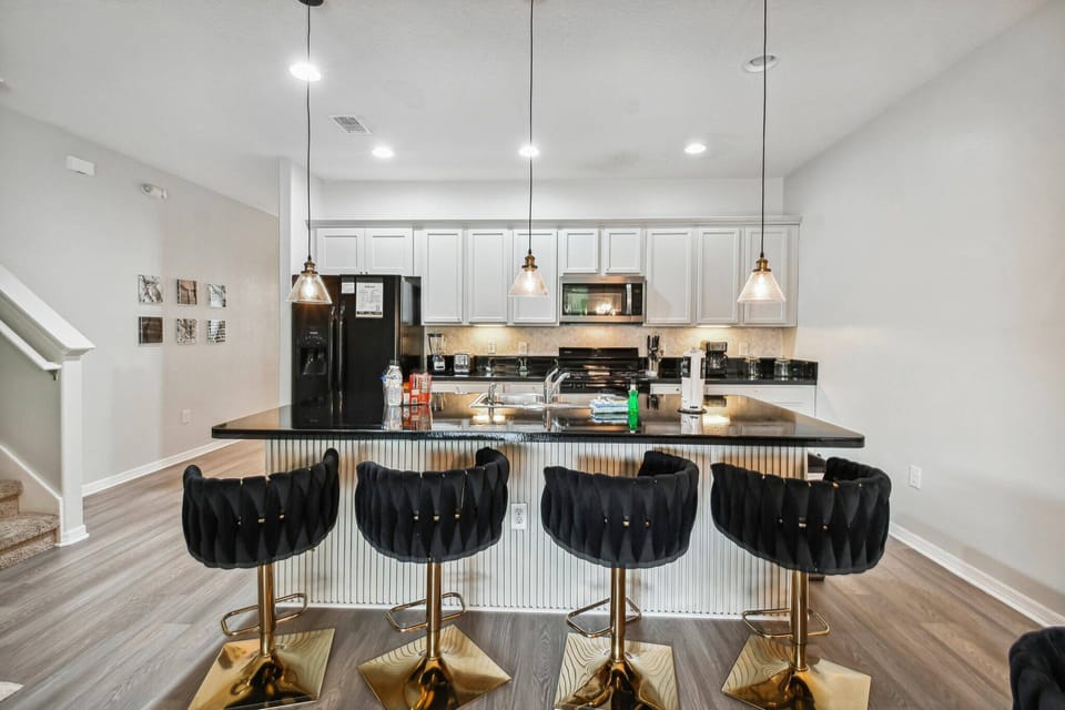 Experience our chic island bar, where elegant black velvet stools meet gold accents, perfect for breakfast or late-night snacks.