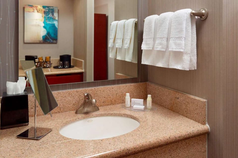 Refresh at the spacious vanity with plush towels and bright lighting.