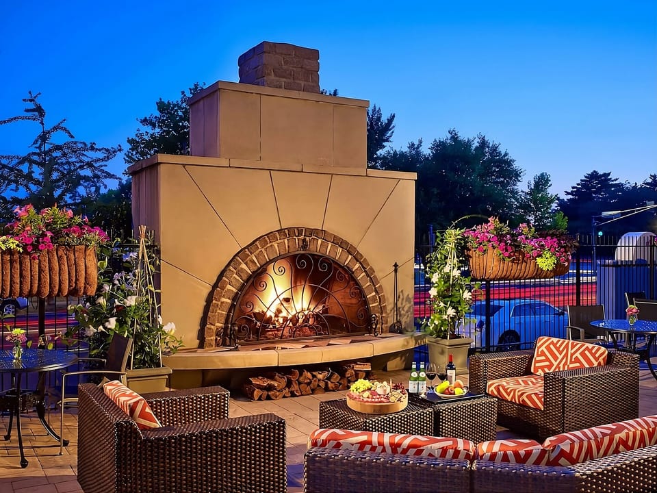 Gather by the glowing outdoor fireplace for cozy evening chats.