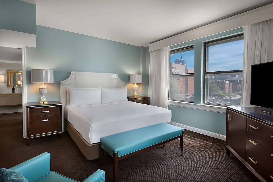 Sink into a plush king bed beside oversized city windows.