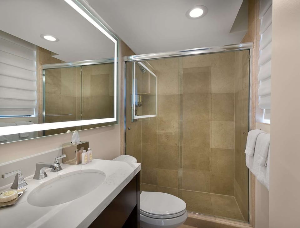 Rinse off in a glass-walled shower with spotless finishes.