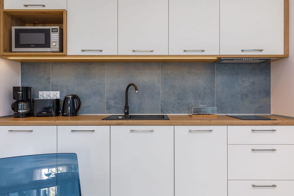 Kitchenette with plenty of kitchen utensils and dishes. 