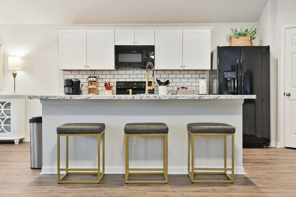 Beautiful kitchen with a nice serving bar and all black appliances