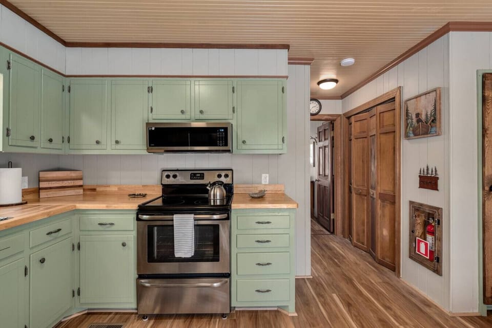 Kitchen with full size electric range, microwave, fridge and dishwasher