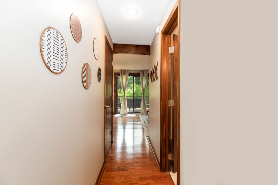 Lower level hall leading to a bedroom, full bathroom, living area, and laundry.
