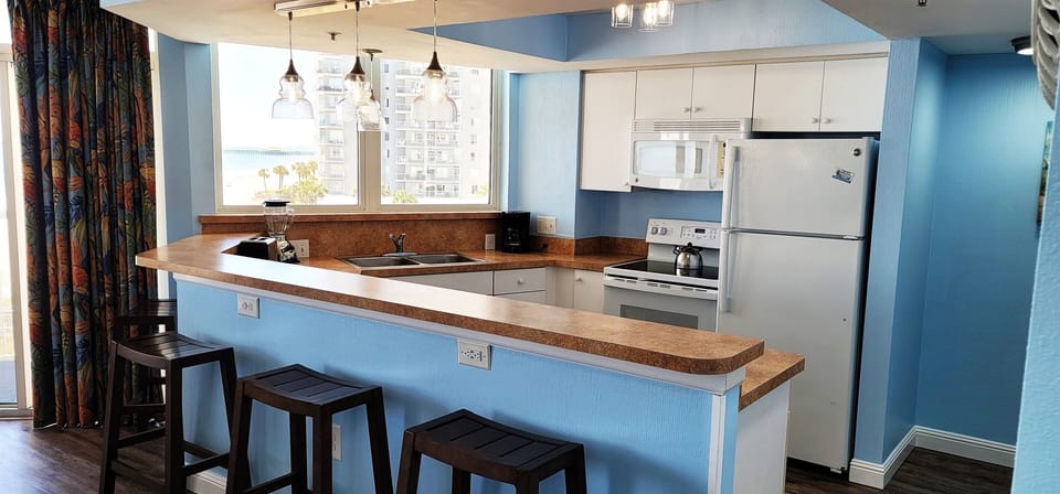 Kitchen has bar stools for extra seating at the counter.