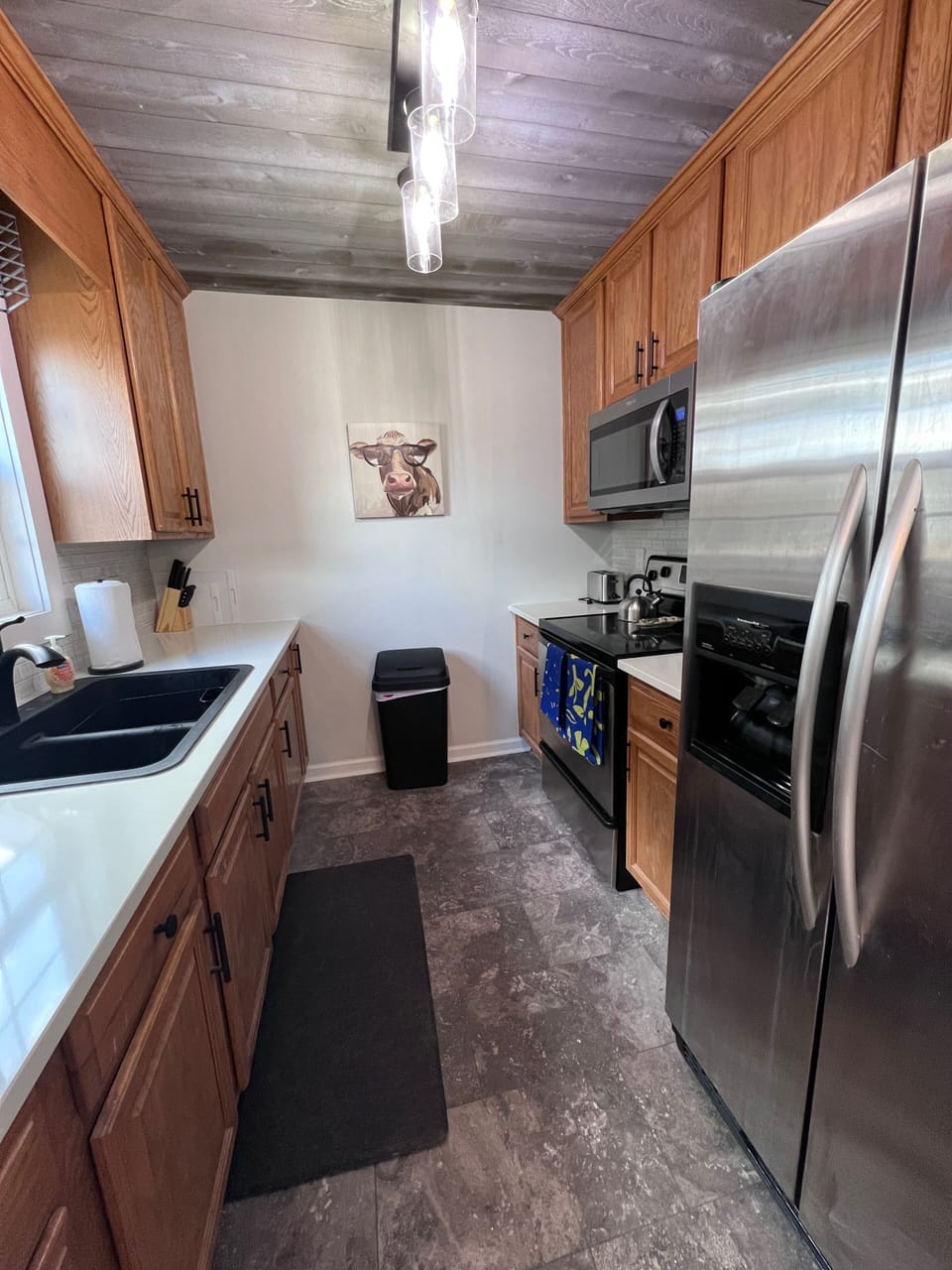 Well-supplied kitchen with natural wood ceiling, coffee bar