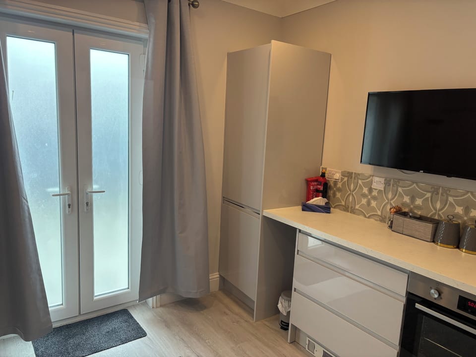 43” smart tv and storage. Patio door to courtyard garden.