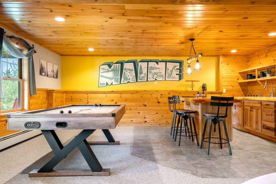 The game room with air hockey table, shuffleboard, Roku TV and bar area 