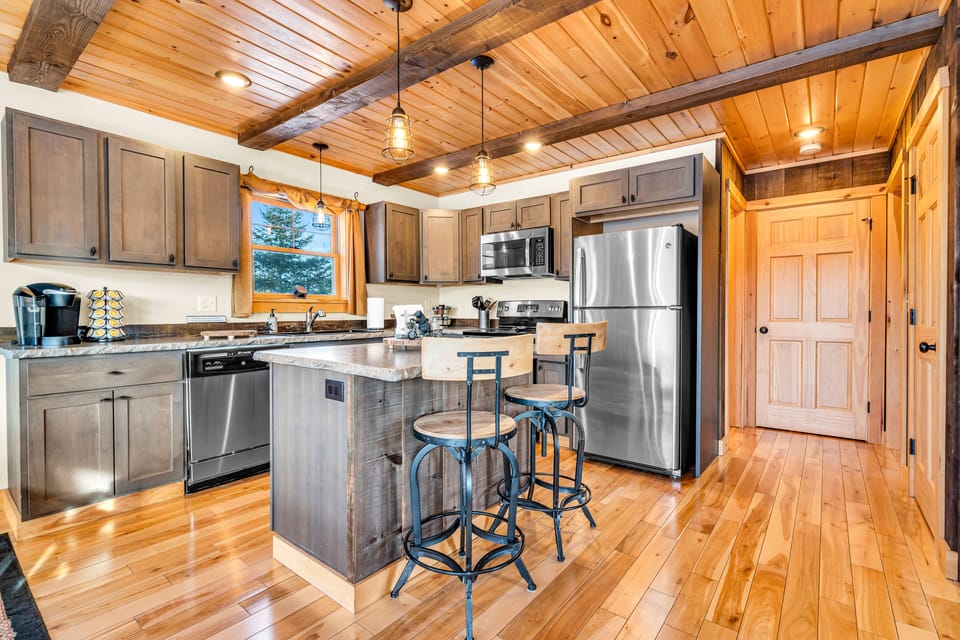 Fully stocked kitchen with stainless steel appliances and concrete counter tops