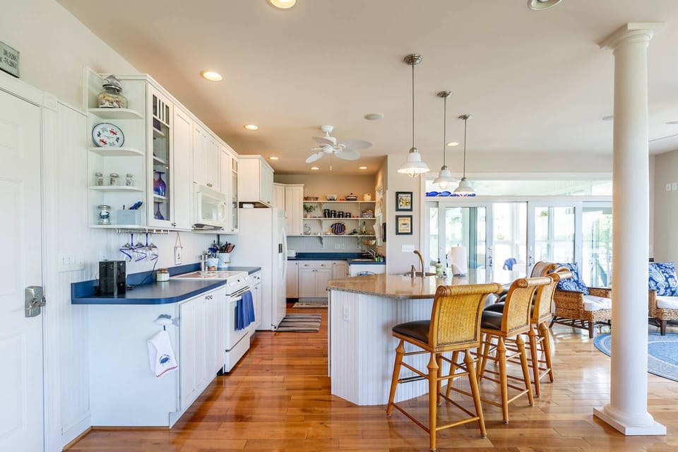 The open floor plan on the main floor includes a gourmet kitchen, counter seating, dining room and sun porch.