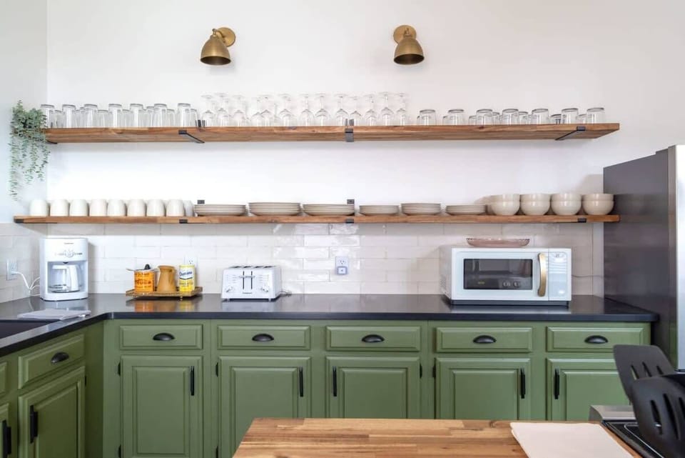 A fully stocked kitchen with dishes, glassware, and a coffee station so you can start your mornings just the way you like. #CoffeeAtHome #AirbnbKitchen