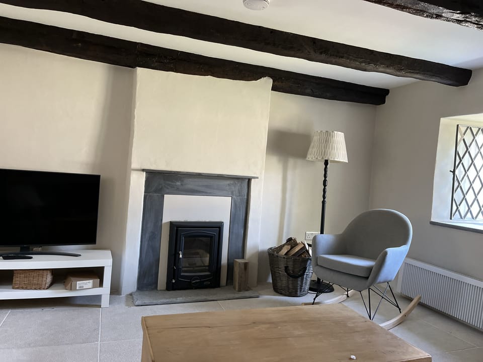 The sitting room,  original beams and wood-burning stove