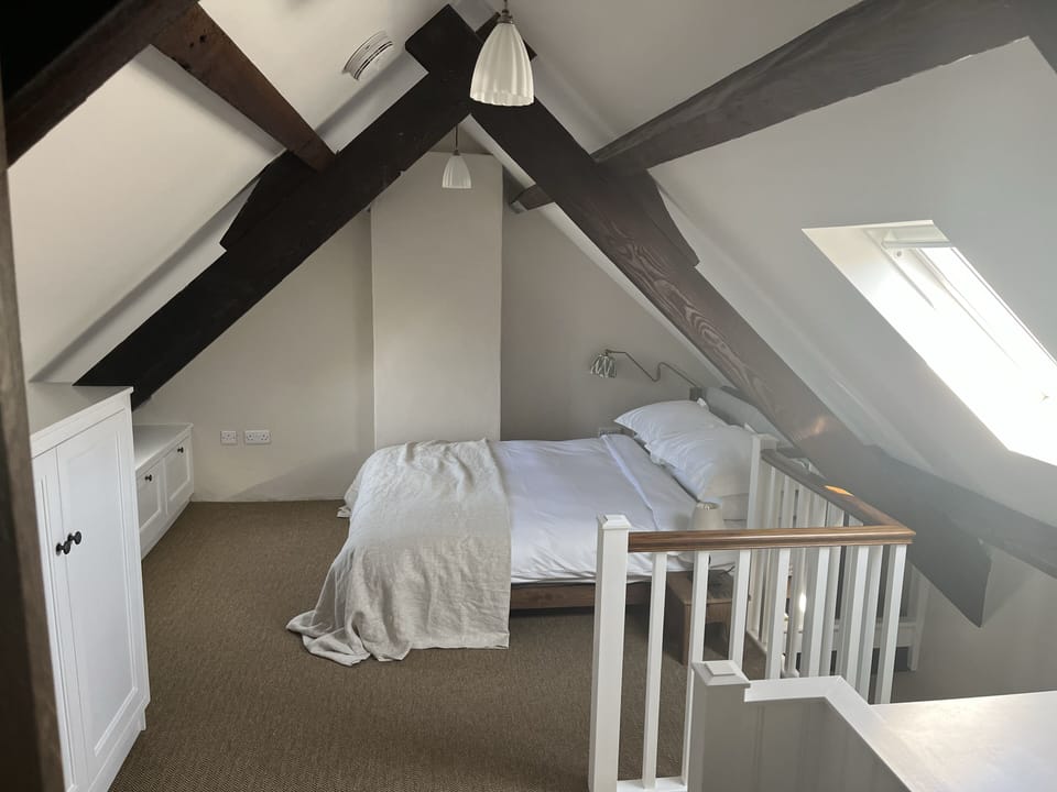 The charter-packed bedroom with dormer window, open trusses and built-in storage